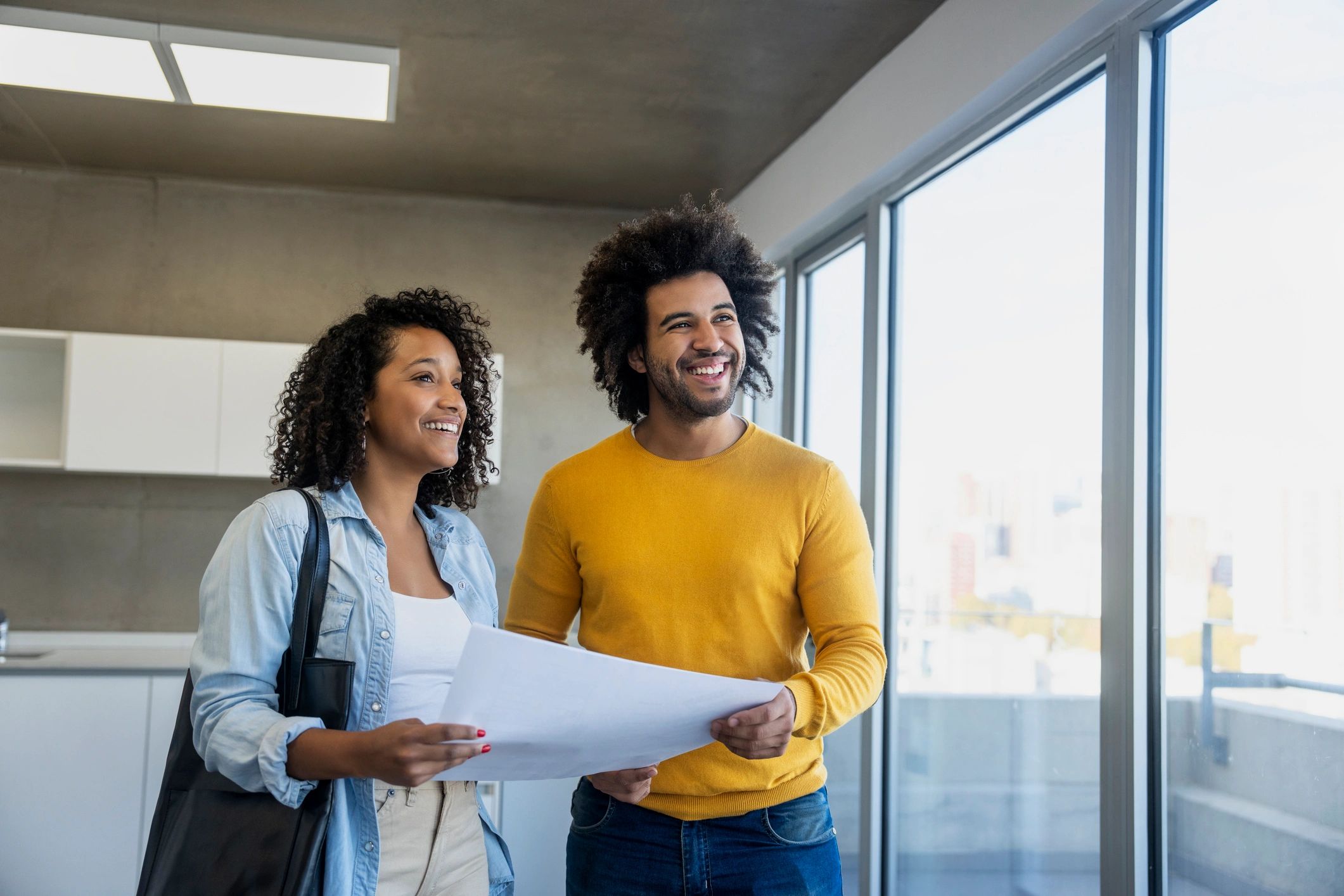 Couple reviewing plans while evaluating a property purchase